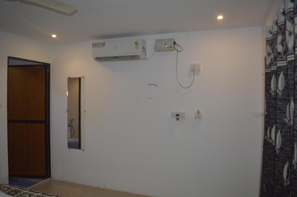 a room with a white wall and a door at Palolem Cottages in Palolem