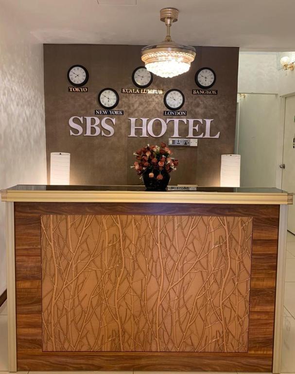 a hotel reception desk with clocks on the wall at SBS HOTEL in Padang Besar