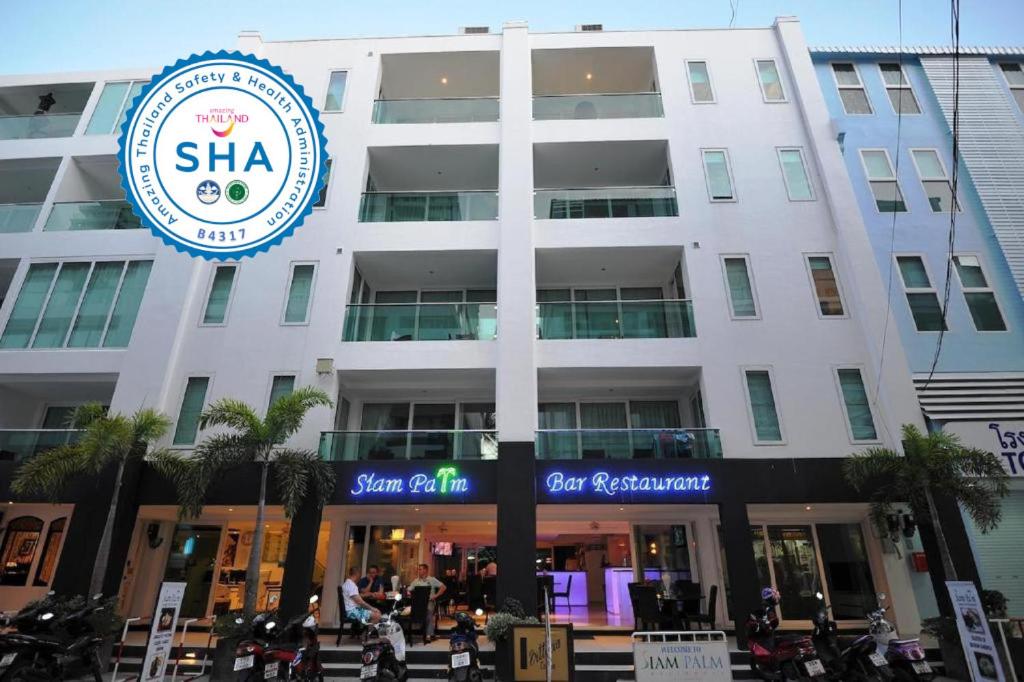 a white building with a sign in front of it at Siam Palm Residence in Patong Beach