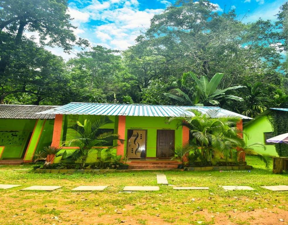 una pequeña casa verde con techo azul en Dandeli Eco VanaVasa by StayApart, en Dandeli