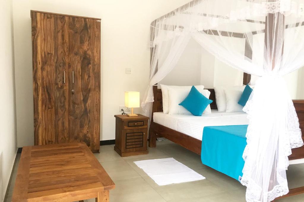 1 dormitorio con cama con dosel y mesa en The Blue Haze Weligama en Weligama
