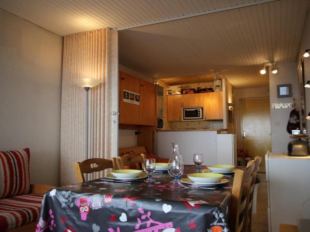 eine Küche und einen Tisch mit einem Tischtuch drauf in der Unterkunft Studio Chamrousse, 1 pièce, 4 personnes - FR-1-549-64 in Chamrousse