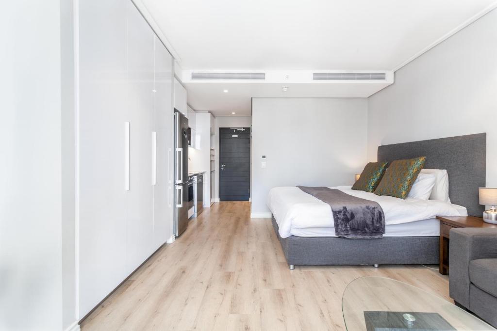 - une chambre avec un lit et un salon dans l'établissement Luxurious 16 on Bree Studio Apartment - Harbour Views, au Cap