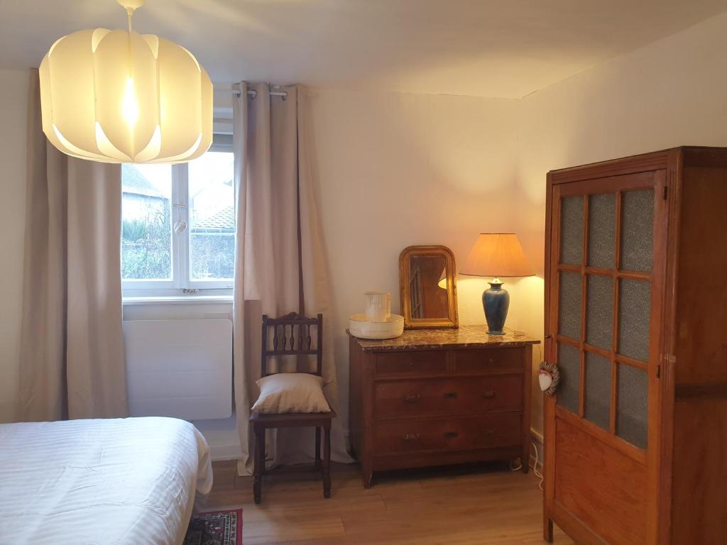a bedroom with a bed and a dresser and a mirror at Au jardin de Lucie in Sainte-Croix-en-Plaine