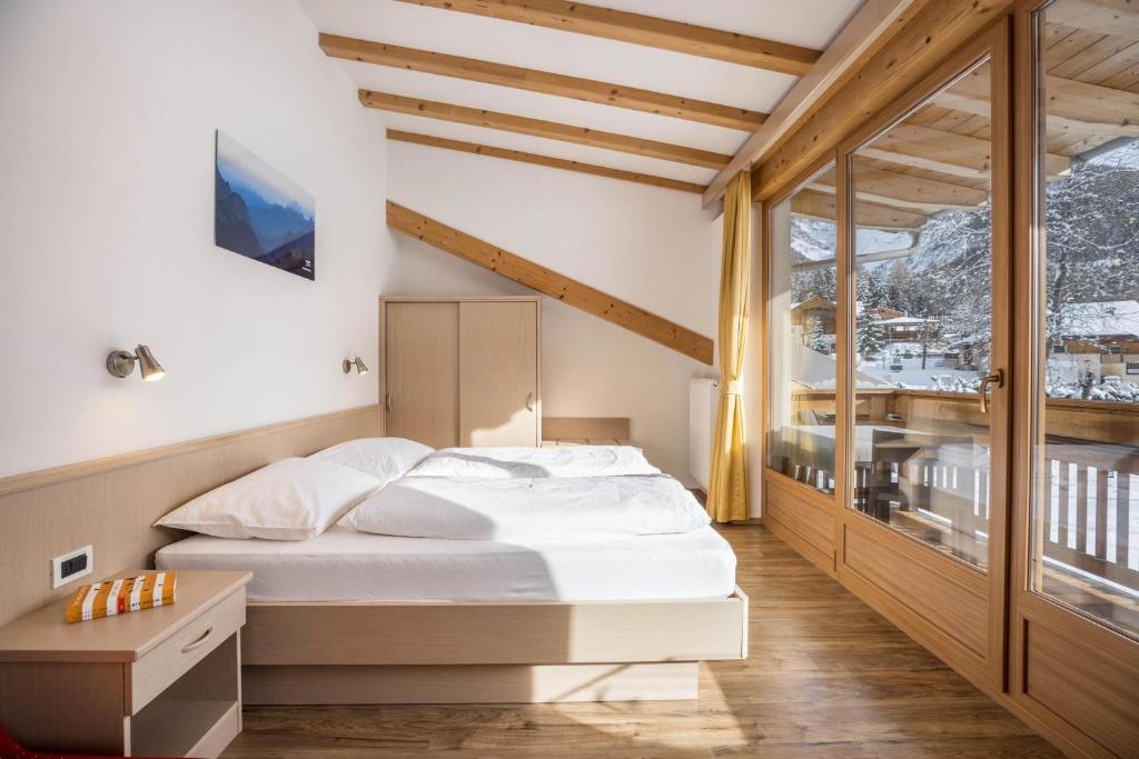 um quarto com uma cama branca e uma varanda em Runcac Apt Gomina em San Vigilio Di Marebbe