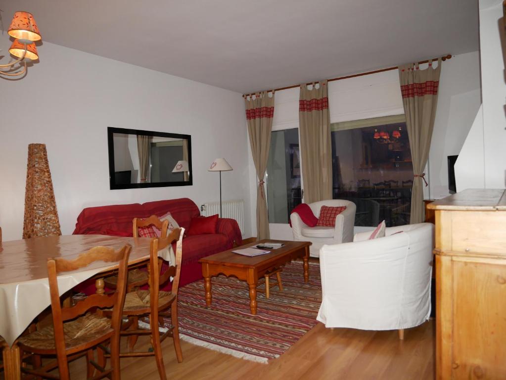 a living room with a red couch and a table at Apollo-Vacances Pirinenca in Soldeu