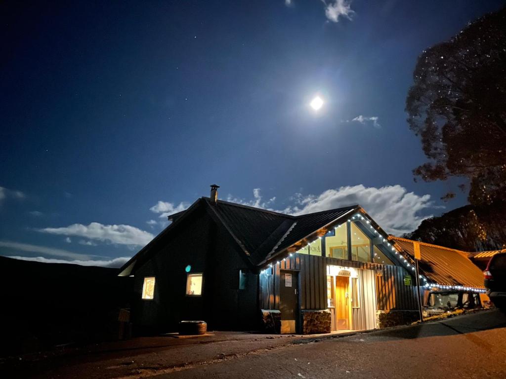 een zwart gebouw met de maan in de lucht bij Cooroona Alpine Lodge in Falls Creek