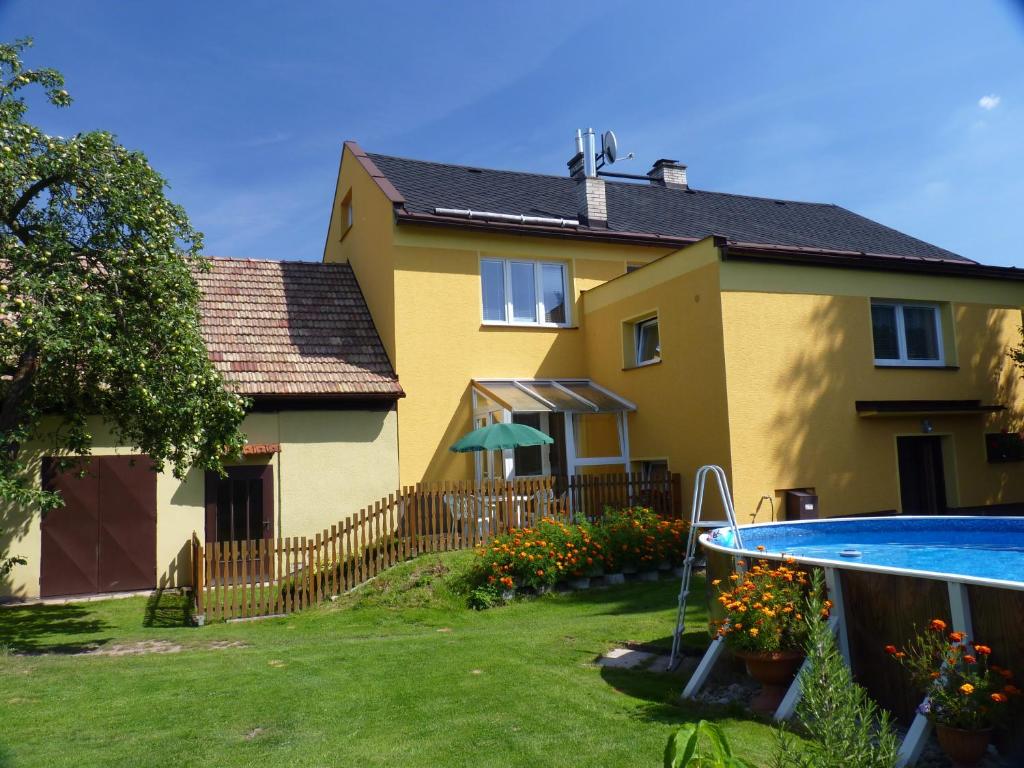 a yellow house with a swimming pool in front of it at Apartmán Novákovi in Náchod