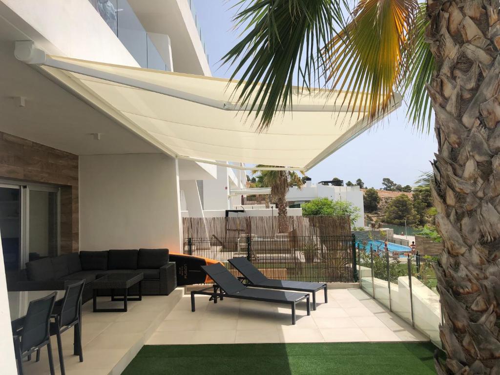 a living room with a couch and chairs and a palm tree at Martormar in Finestrat