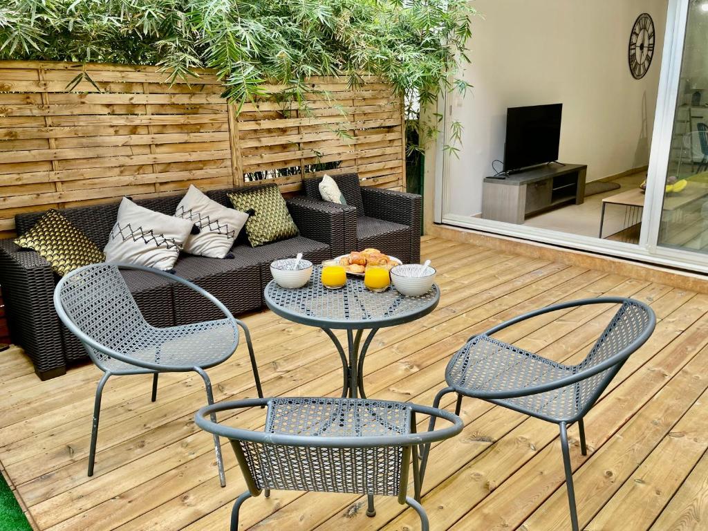 a patio with two chairs and a table and a couch at Nouveauté - L'Oasis - T3 - 70 M2 - Jacuzzi in Saint-Denis