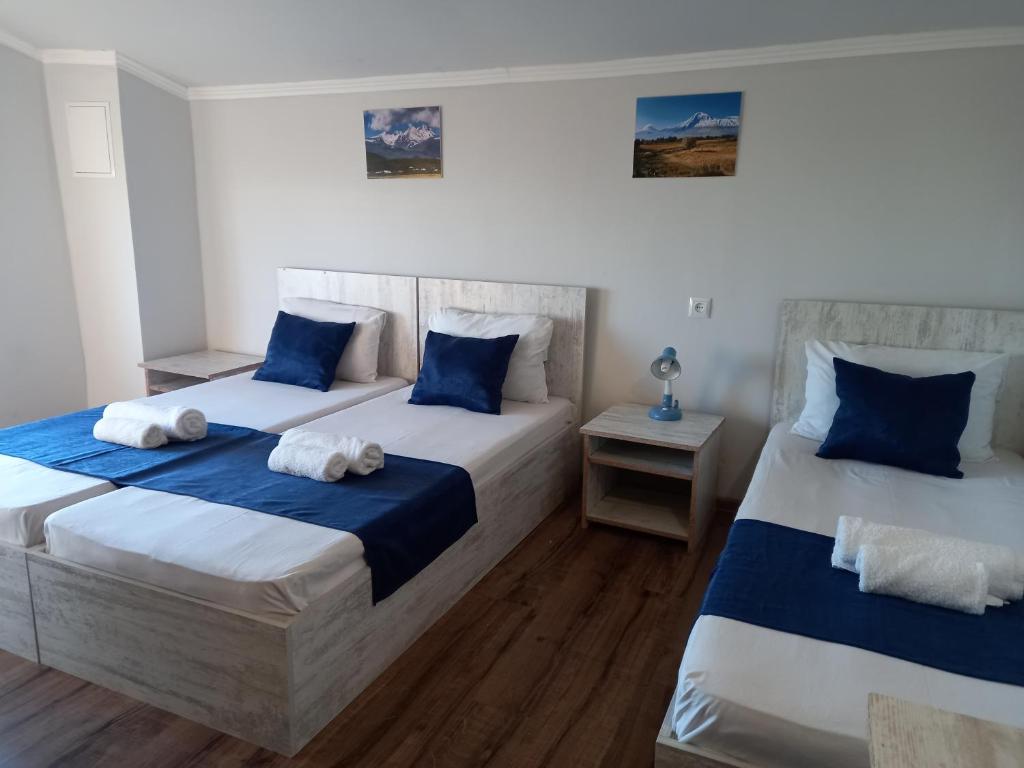 two beds in a room with blue and white at Byurakan Guesthouse & Cottage in Byurakan