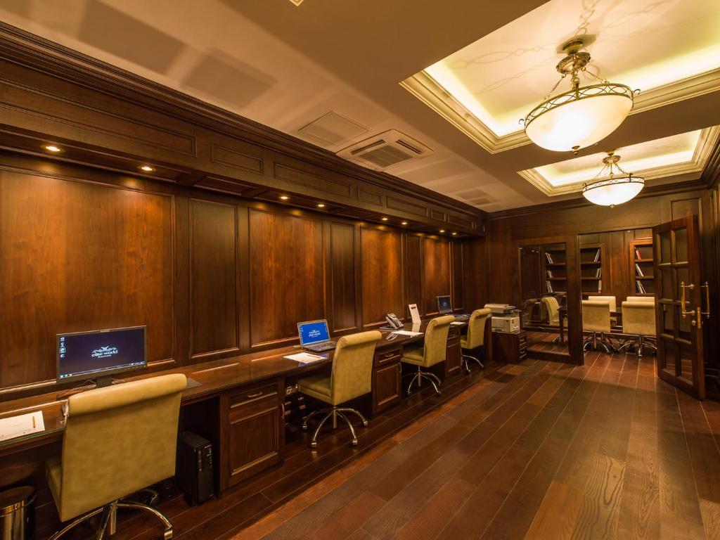 an office with wooden walls and desks and chairs at Elite World Istanbul Florya in Istanbul