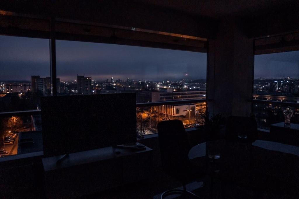 ヴィリニュスにあるVilniausPanoramaの夜の市街の景色を望む客室