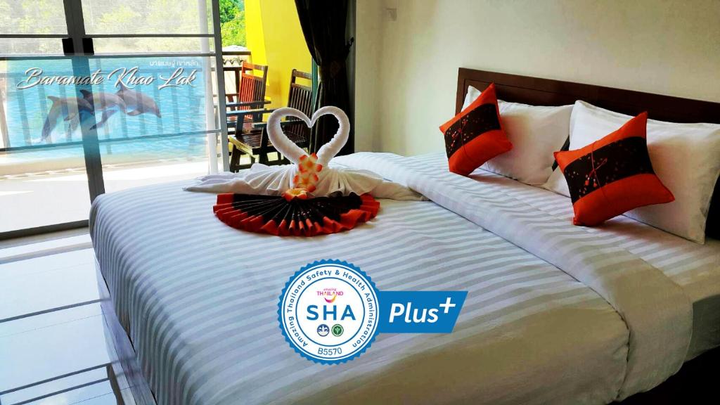 a hotel bed with a sign that says shka plus at Baramate Khao Lak - SHA PLUS in Khao Lak