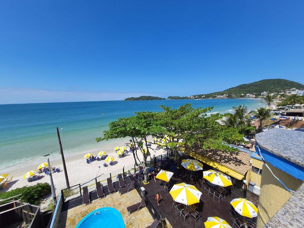 een uitzicht op een strand met parasols en de oceaan bij Pousada Refugio Costeiro in Bombinhas