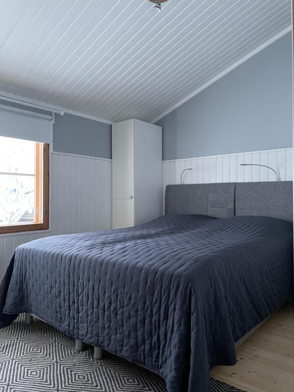 een slaapkamer met een bed met een blauw dekbed bij Rukan Tähtihelmi Kelokivakka b12 in Ruka