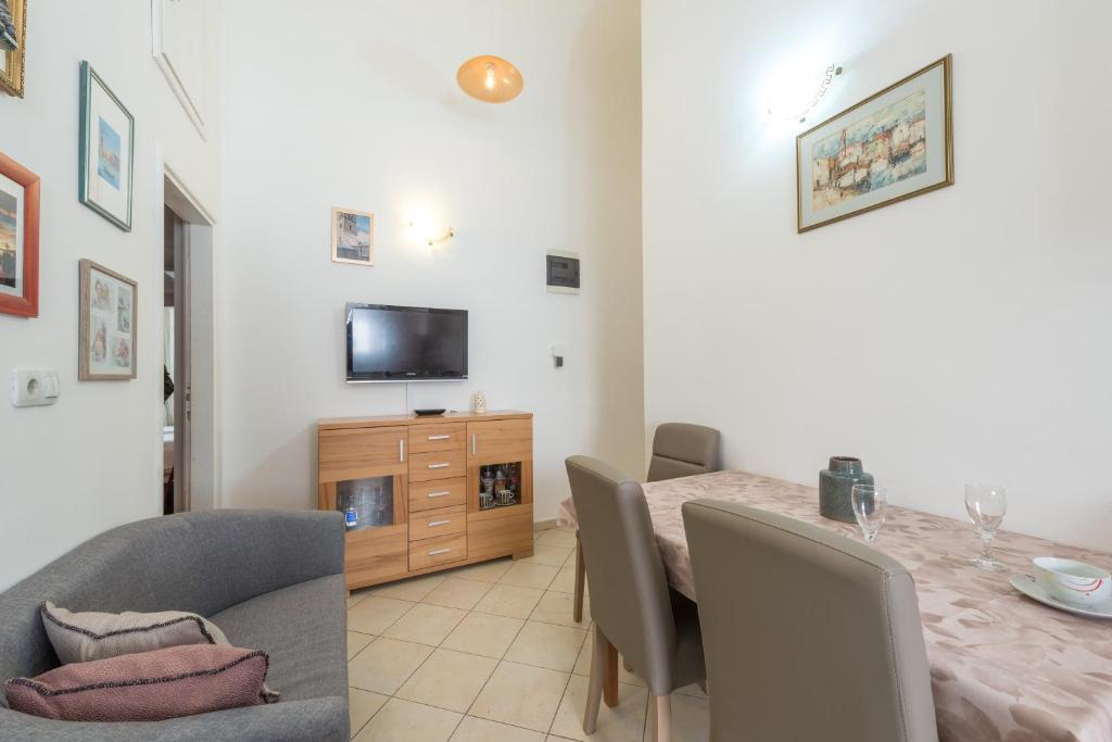 a dining room with a table and a television at Old Writer Apartment in Dubrovnik