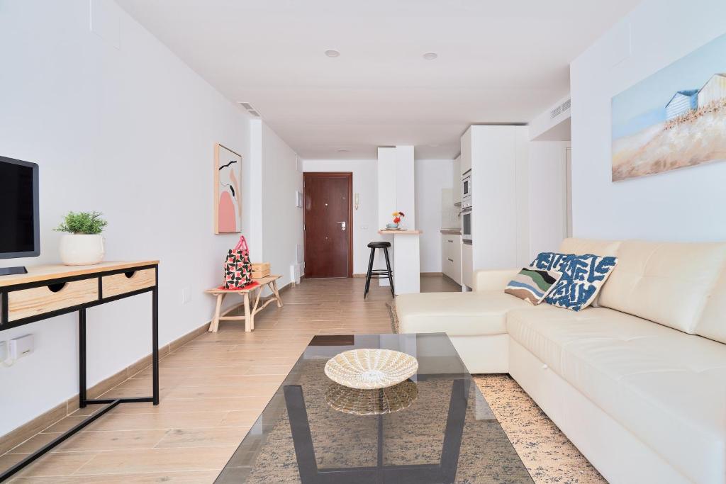 salon z białą kanapą i stołem w obiekcie Apartamento en primera linea de playa en la Malagueta w Maladze