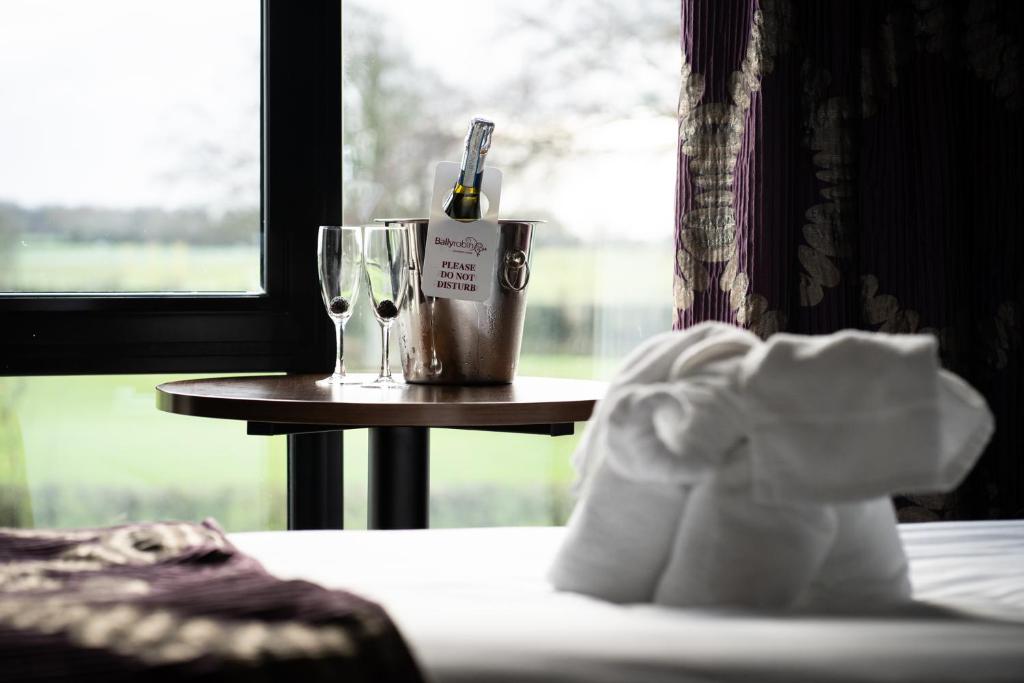 a table with a bottle of wine and a glass at Ballyrobin Hotel in Aldergrove