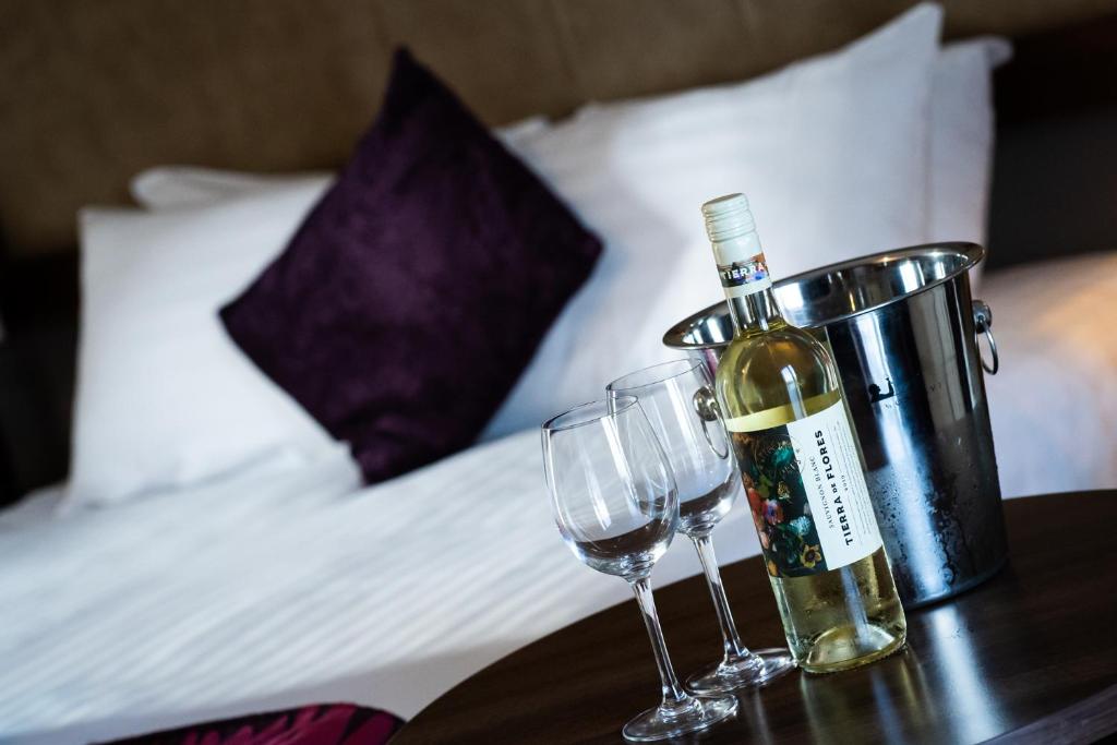 a bottle of wine and two glasses on a table at Ballyrobin Hotel in Aldergrove