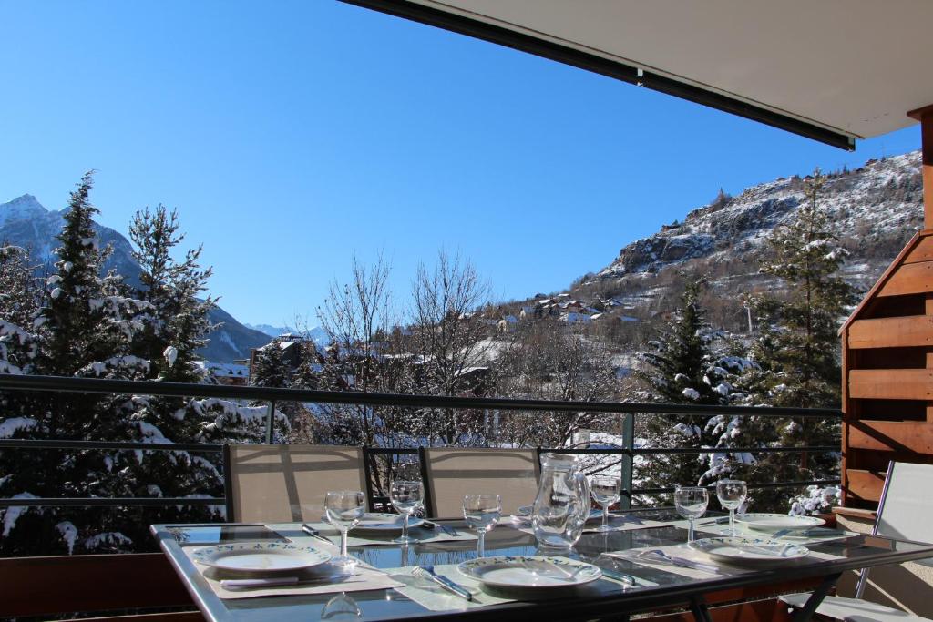 a table on a balcony with a view of a mountain at L'orée des pistes Serre Chevalier Briançon in Briançon