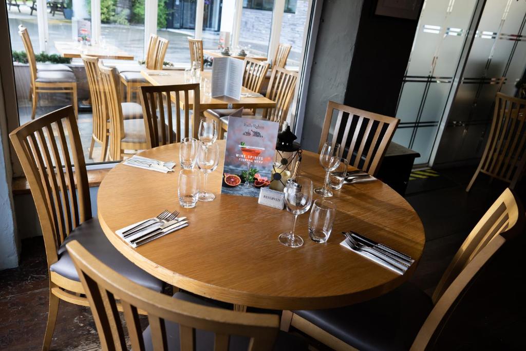 a wooden table in a restaurant with glasses on it at Ballyrobin Hotel in Aldergrove