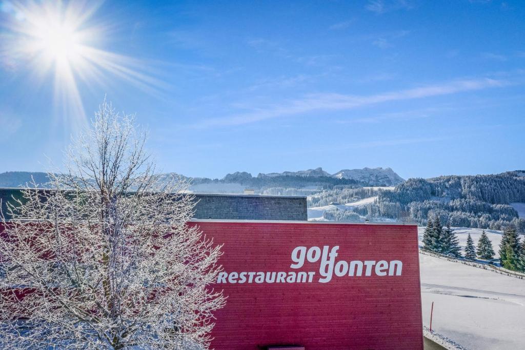 a sign on the side of a building in the snow at Swiss Mountain Golf-Restaurant Gonten in Gonten