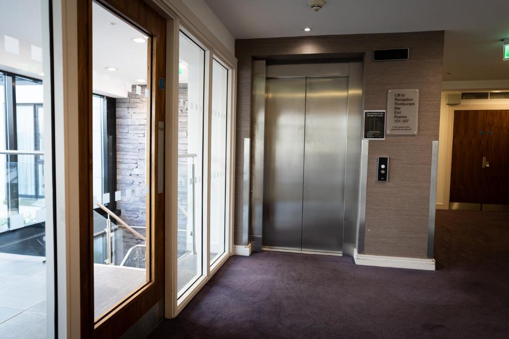a hallway with a elevator in a building at Ballyrobin Hotel in Aldergrove