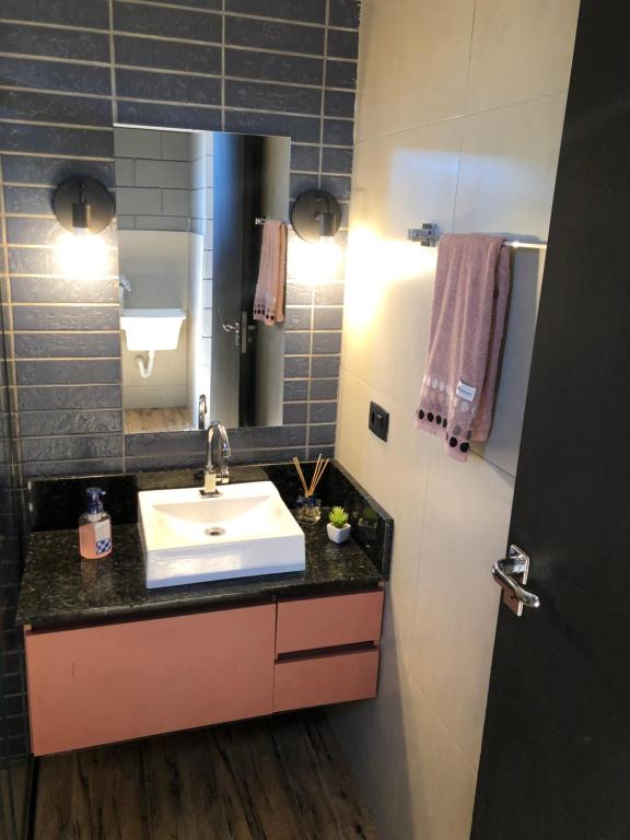 a bathroom with a sink and a mirror at Flats do Lago in Faxinal