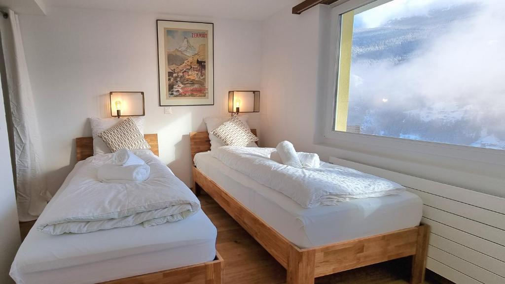 Postel nebo postele na pokoji v ubytování Mattertal Lodge
