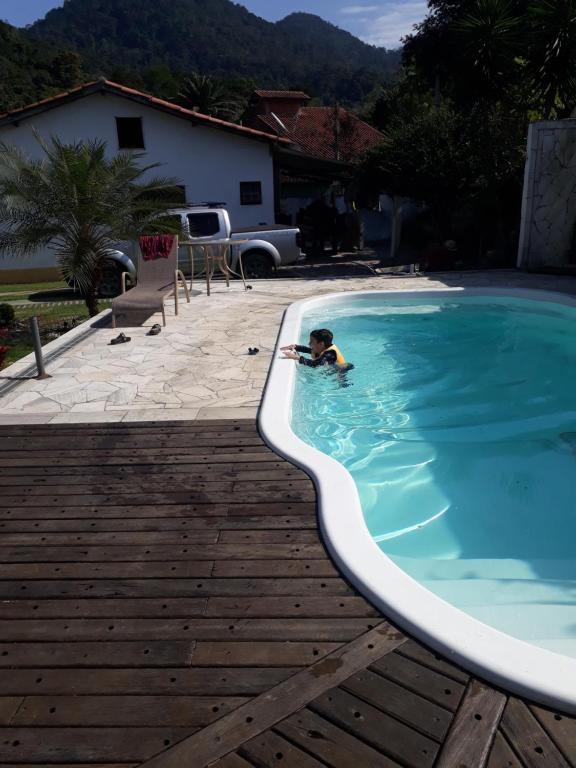 a child swimming in a swimming pool at Casa Pousada Cantinho Secreto in Ubatuba