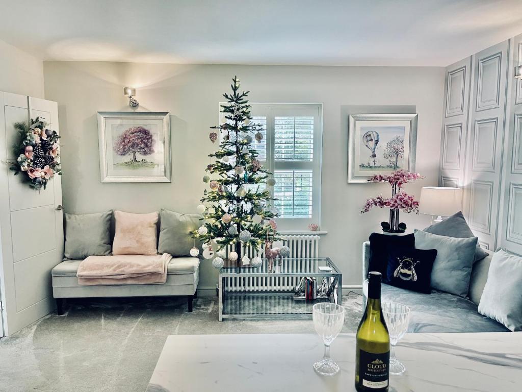 a living room with a christmas tree and a wine bottle at Cotswold Chic Retreats "Cloud Nine" Central Chipping Campden-Parking-Garden in Chipping Campden