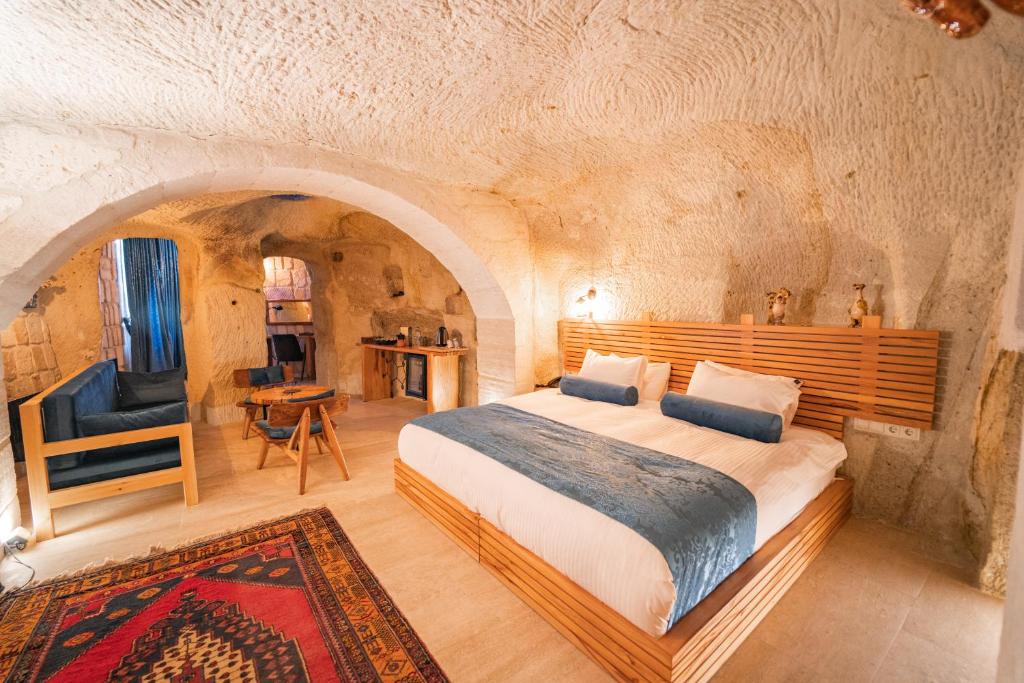 a bedroom with a large bed in a stone room at Agarta Cave Hotel in Goreme