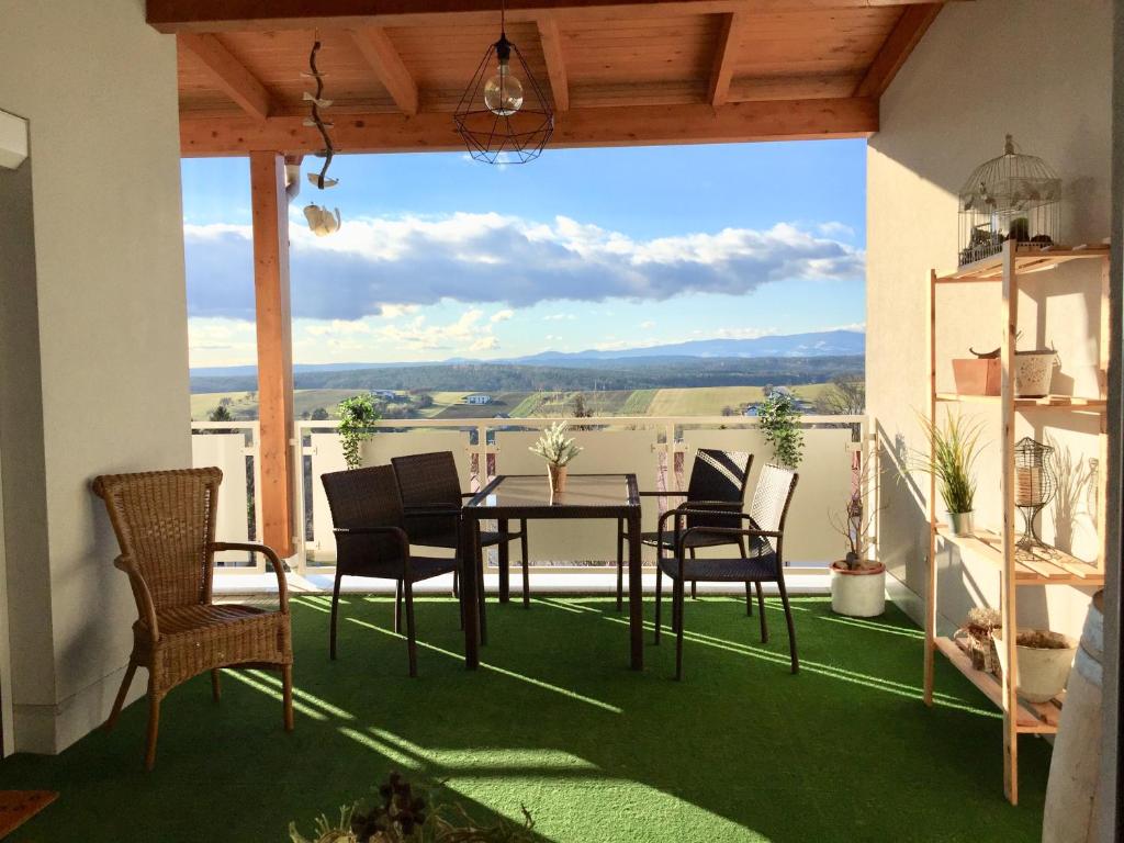 Oberschützen的住宿－Apartment Panoramablick mit Infrarotkabine auf der großen Terrasse und traumhaften Ausblick，享有美景的庭院配有桌椅。