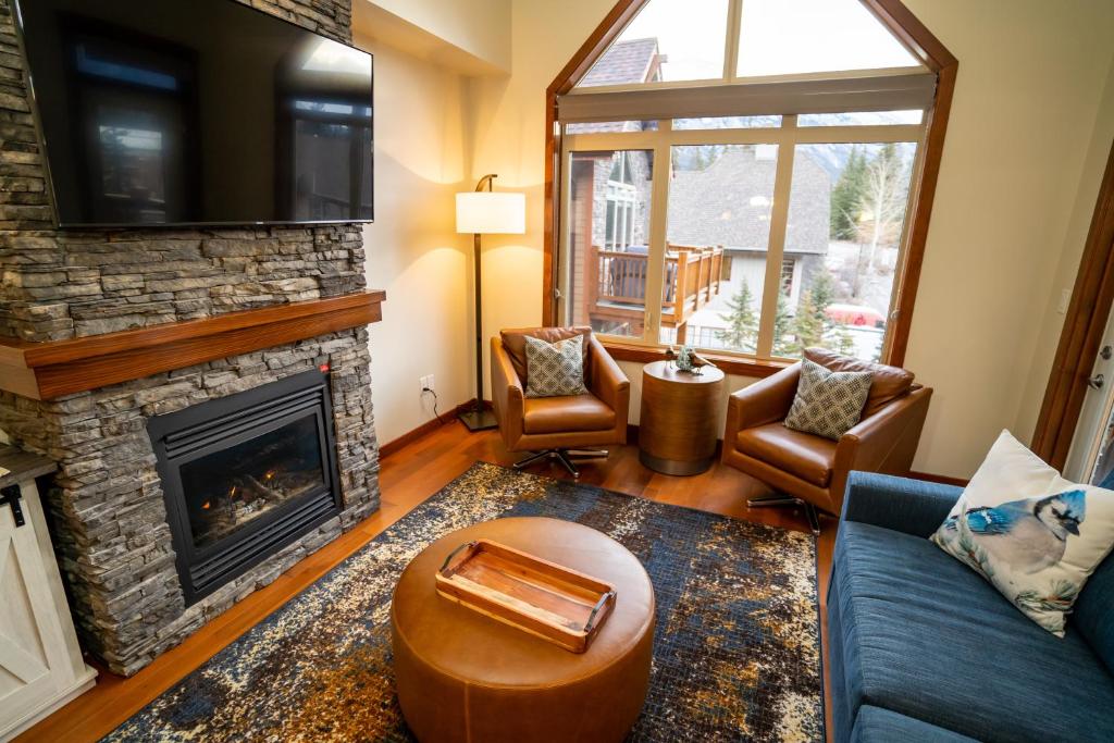 a living room with a couch and a fireplace at The Raven Suite at Stoneridge Mountain Resort in Canmore