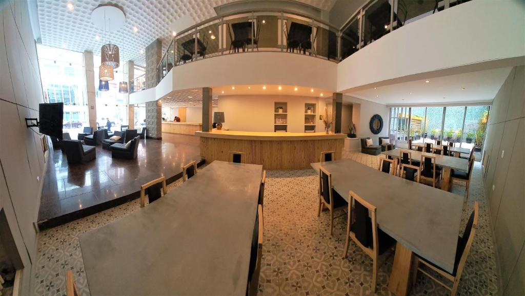 un restaurante con mesas y sillas y un bar en Hotel América en Mar del Plata