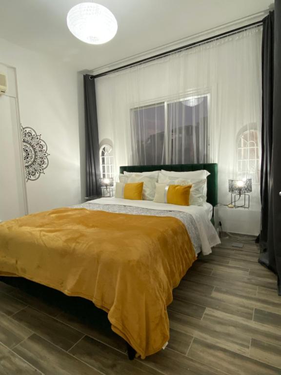 a bedroom with a large bed with a yellow blanket at Boho-Chic one bedroom flat in Engomi in İncirli