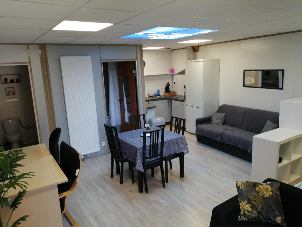 a living room with a table and chairs and a couch at Appart'Hôtel Bugey in Sainte-Julie