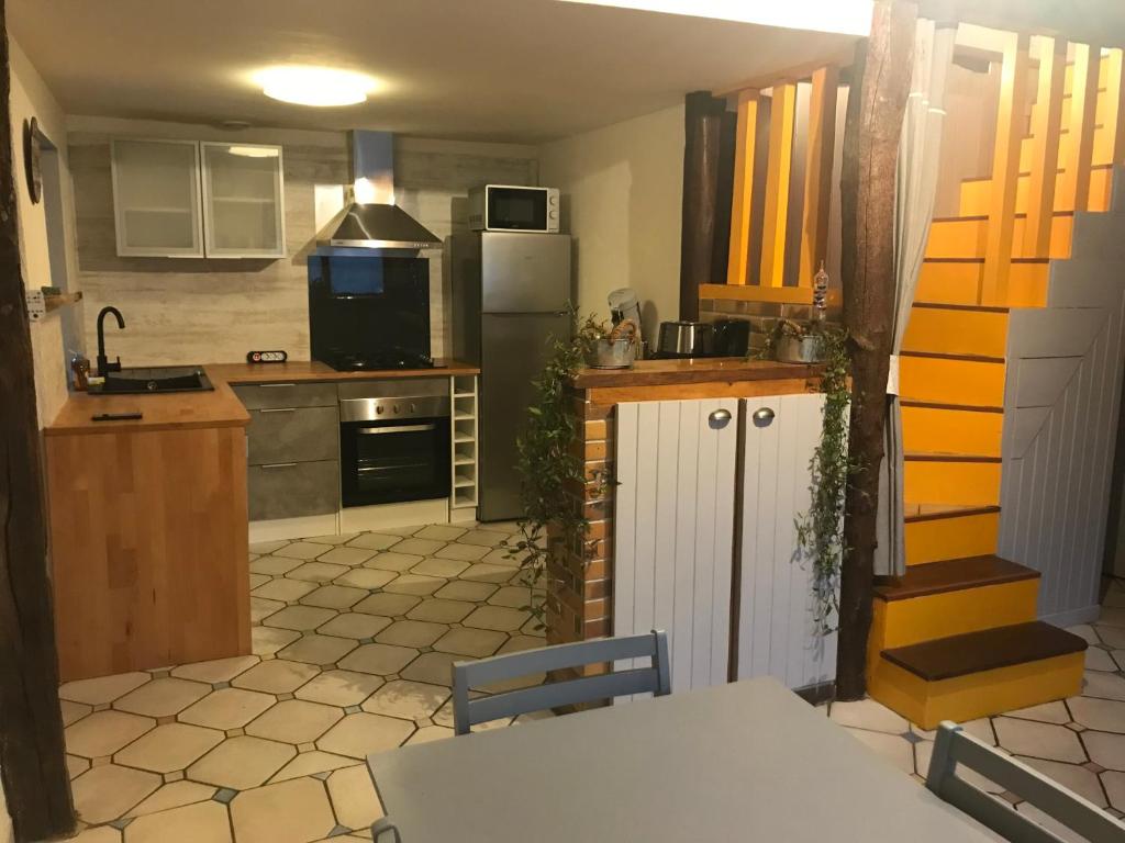 een keuken met een tafel en een keuken met een koelkast bij P’tite House in Bretenoux