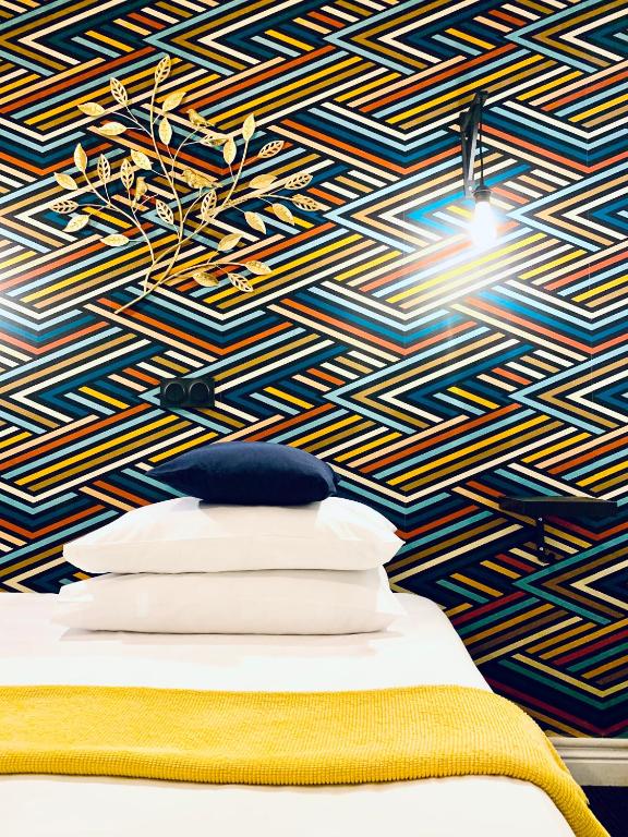 a bedroom with a blue and yellow patterned wall at Hôtel Gaspard in Le Touquet-Paris-Plage