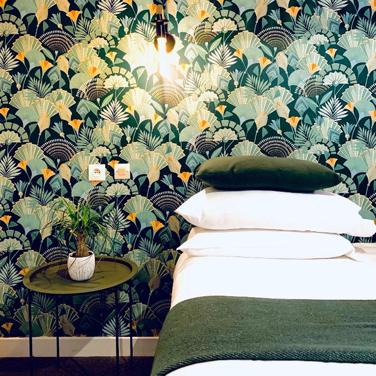 a bedroom with a bed with a floral wallpaper at Hôtel Gaspard in Le Touquet-Paris-Plage