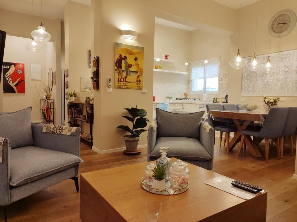 a living room with chairs and a table and a kitchen at Nettas luxurious central Jerusalem Ap in Jerusalem