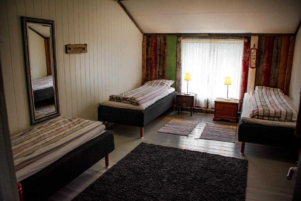 a room with two beds and a mirror and a window at Villa Vengetind in Isfjorden