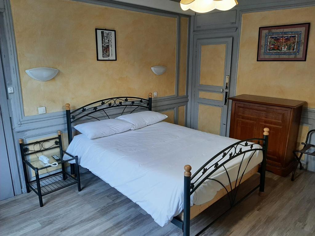 a bedroom with a large bed and a night stand at Hôtel Les Beaux Arts- Limoges Hypercentre in Limoges