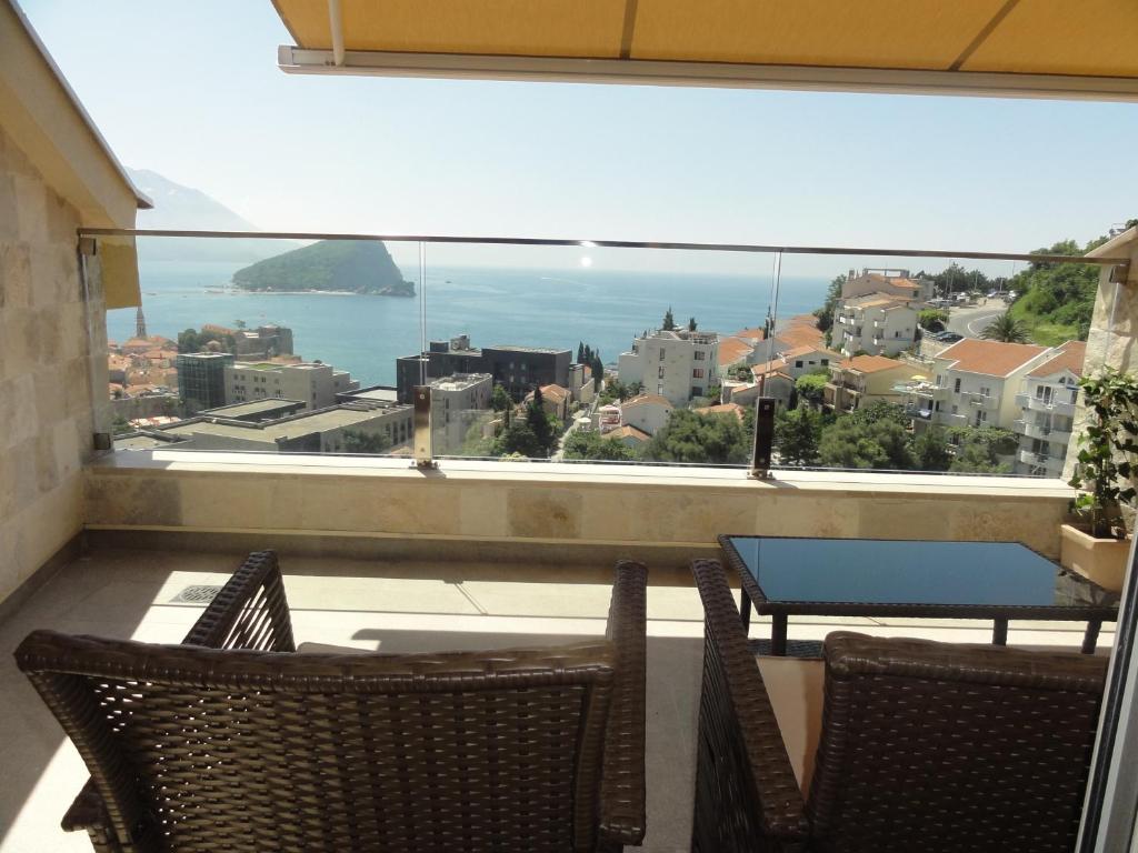 a balcony with a table and chairs and a large window at The Old Town Viewpoint Apartments in Budva