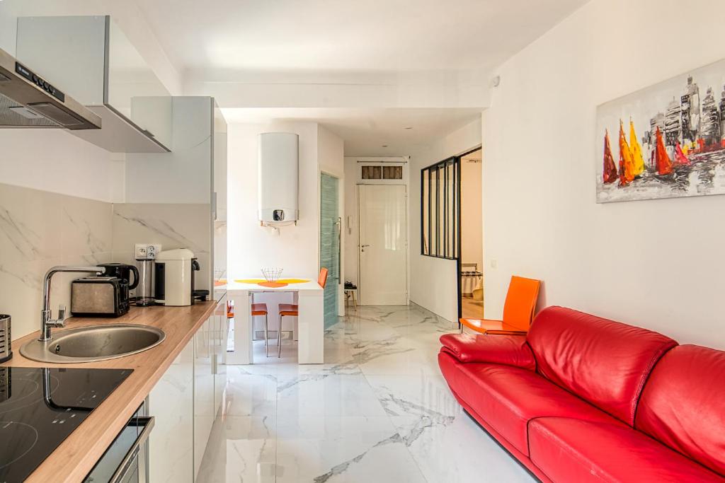 un salon avec un canapé rouge dans une cuisine dans l'établissement SUITE STALINGRAD, à Nice