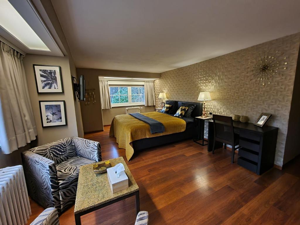 ein Wohnzimmer mit einem Bett und einem Sofa in der Unterkunft Manoir du bois des rêves in Lacroix