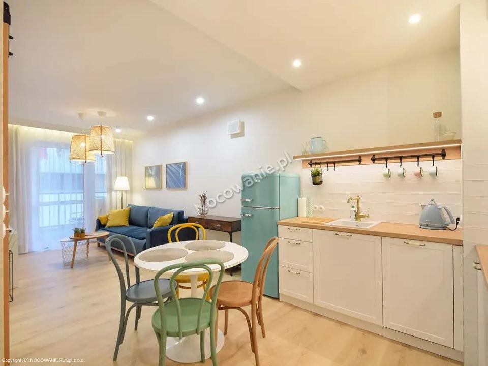 Il comprend une cuisine et un salon avec une table et des chaises. dans l'établissement Apartament Premium IV z Garażem, à Kołobrzeg