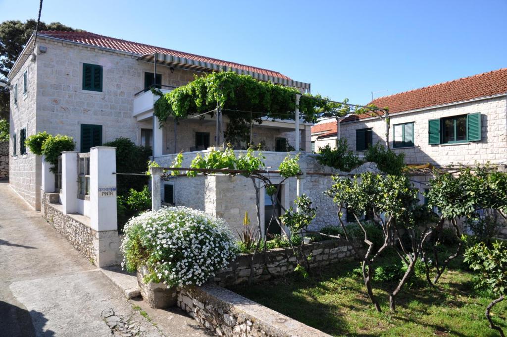 a house with a garden in front of it at Pinta Apartments in Lumbarda
