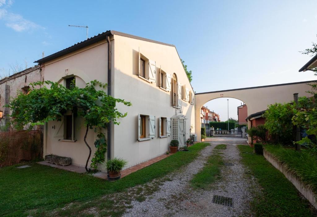 an alley between two buildings with an arch in the background at Rosalimone BeB in Campodarsego